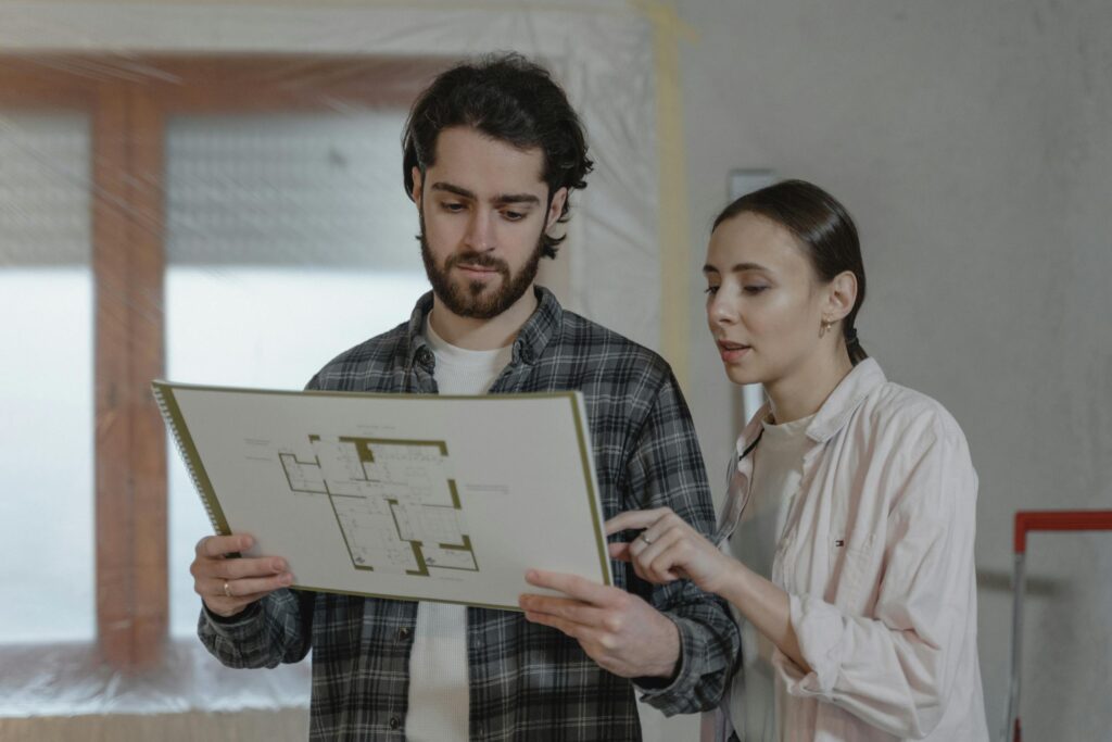 a man and woman examining a floor plan for home improvement indoors 6474498 scaled